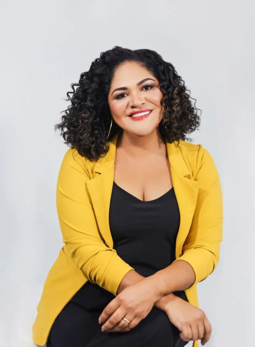 Dra. Alda Ribeiro sorrindo, de blazer amarelo