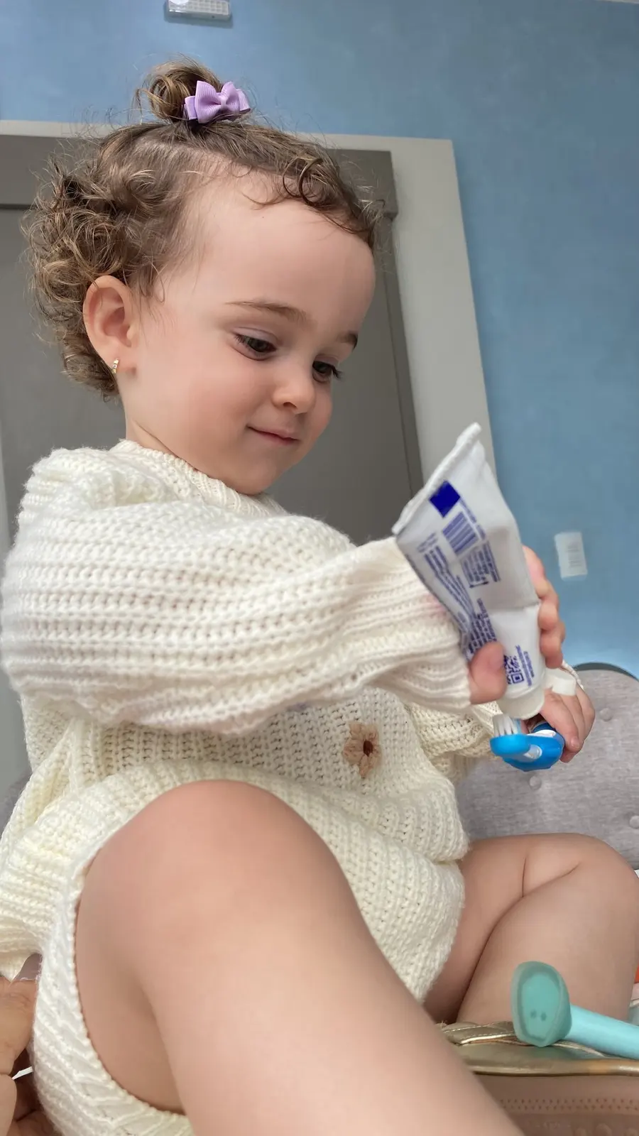 Criança pequena brincando com escova e creme dental