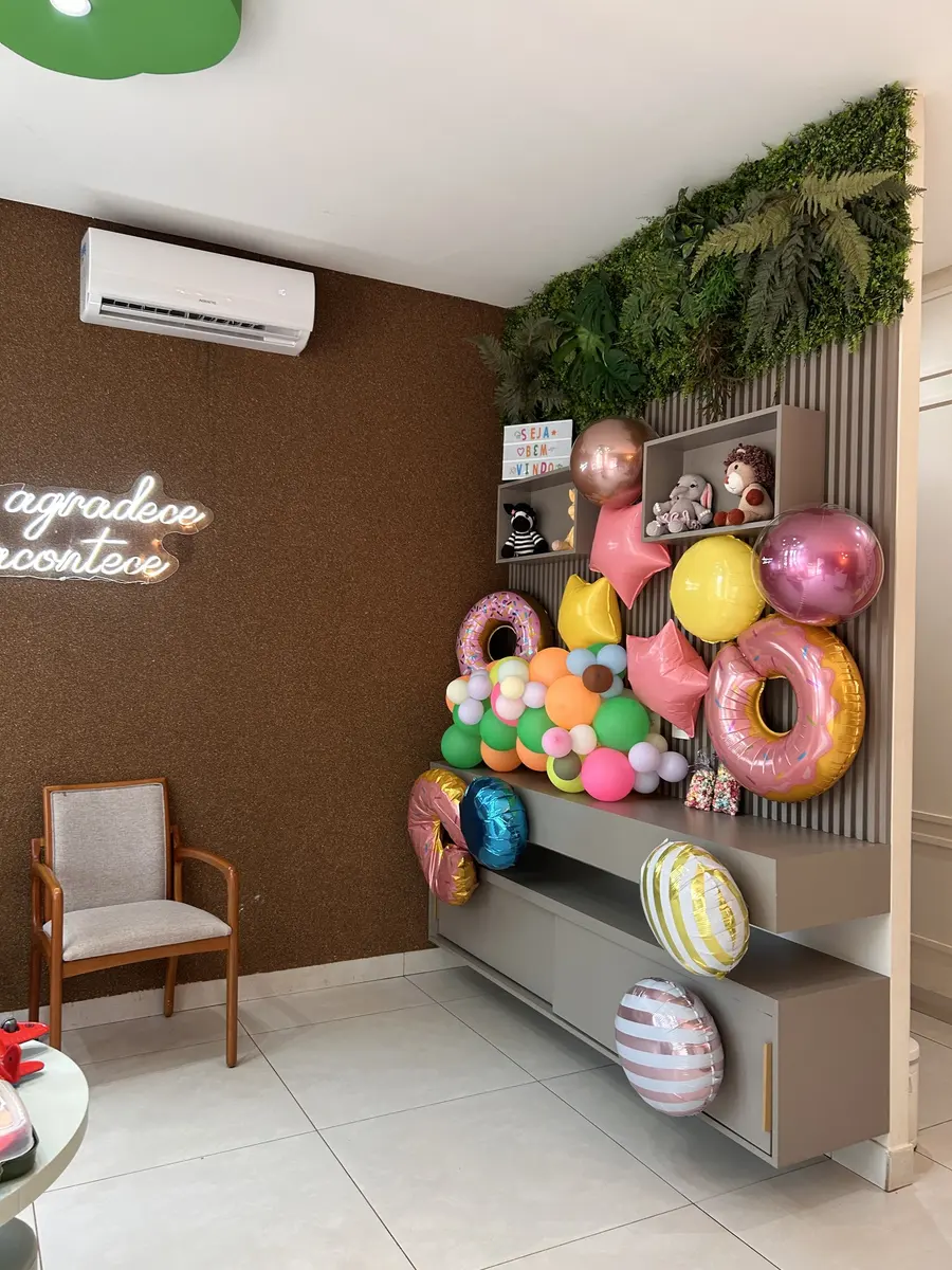 Parede de balões coloridos e brinquedos na sala de espera